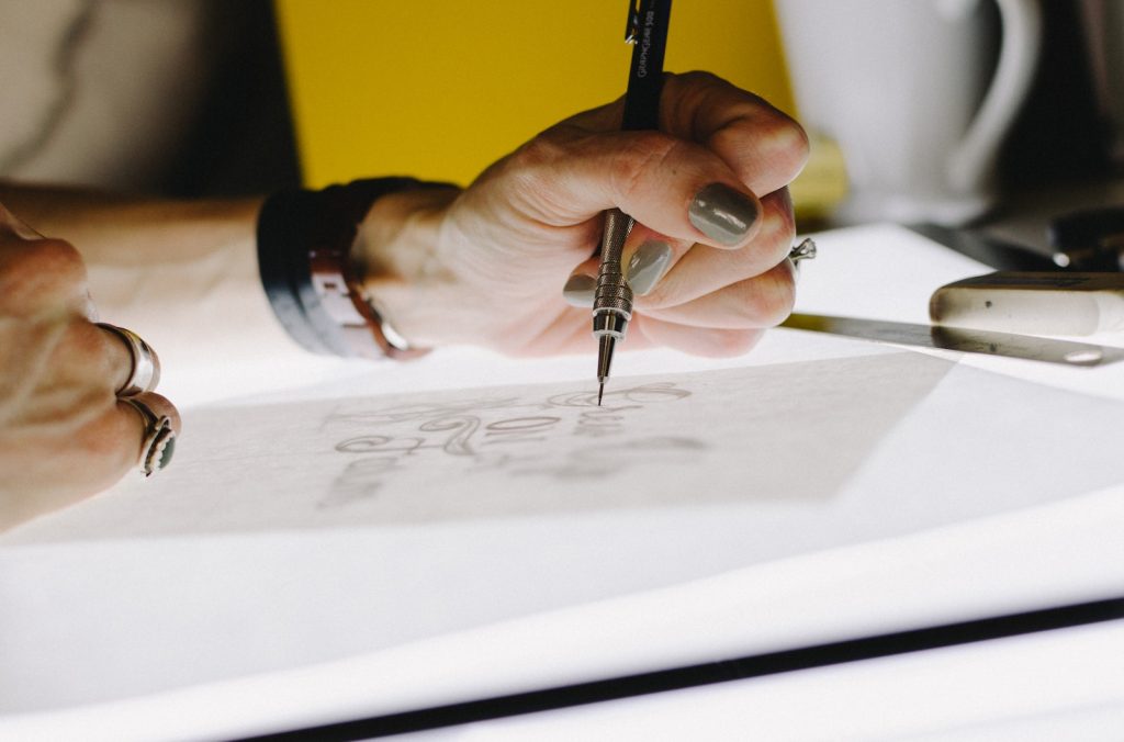 Person using mechanical pencil to design on tracing paper