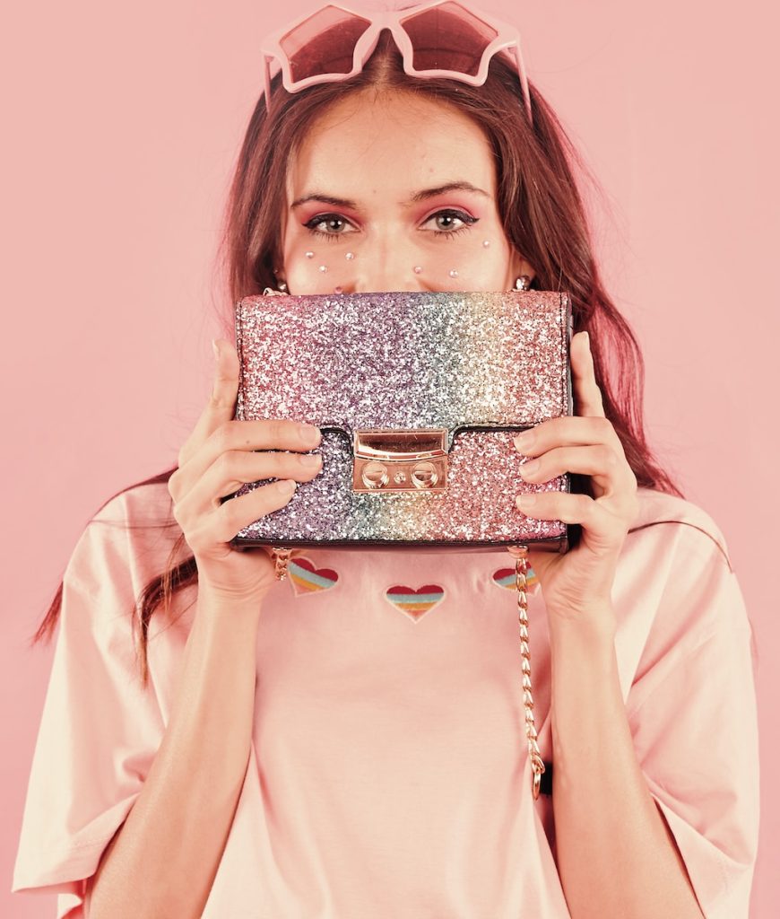 woman in pink long sleeve shirt holding handbag